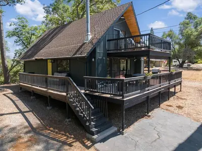 a small green house with decks and a roof at Peaceful Pines Escape Near Yosemite, Lake & Golf in Groveland
