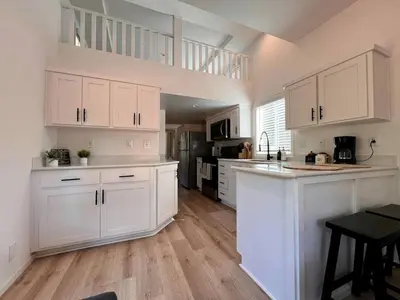 a kitchen with white cabinets and a kitchen island at Bright Modern Tiny Retreat with Yoga Dome Near Yosemite, Groveland, California in Groveland