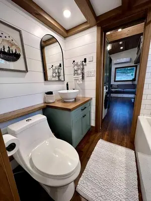 a bathroom with a toilet and a sink in an rv at Cozy Modern Tiny Retreat with Yoga Dome, Garden, and Stargazing in Groveland, California in Groveland