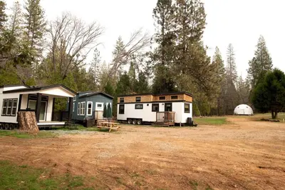 a group of tiny homes parked in a field at Cozy Modern Tiny Retreat with Stargazing & Yoga Dome Access Near Yosemite Tioga Pass, Groveland, California in Groveland