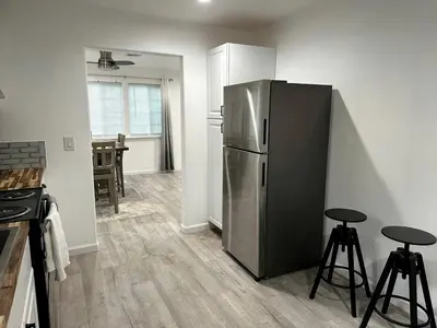 a kitchen with a stainless steel refrigerator and two stools at Cozy Nature-Filled Home with Garden & Night Sky Views Near Yosemite Tioga Pass, Groveland CA in Groveland