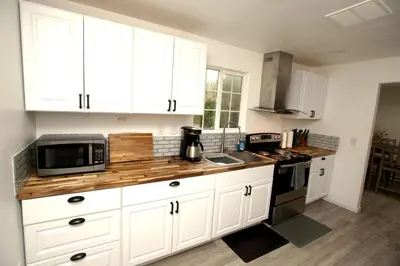 a kitchen with white cabinets and a wooden counter top at Cozy Nature-Filled Home with Garden & Night Sky Views Near Yosemite Tioga Pass, Groveland CA in Groveland