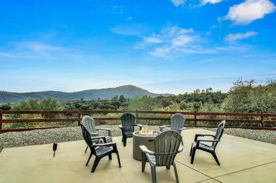 a table and chairs on a patio with a view at Twilight Villa,Hot Tub,EV Charger,Yosemite and Bass lake in Oakhurst
