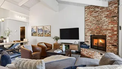 a living room with couches and a brick fireplace at Pinecone Peak by AvantStay Incline Village Condo Fireplace Balconies Pool Access in Incline Village