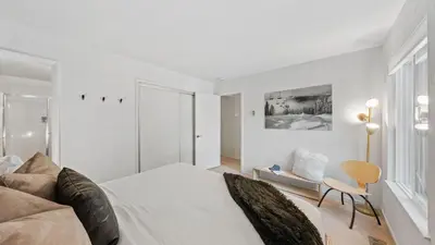 a white bedroom with a bed and a chair at Les Roes by AvantStay Incline Village Retreat • Near Lake Tahoe Beaches and Scenic Trails Diamond Peak and Local Hot Spots in Incline Village