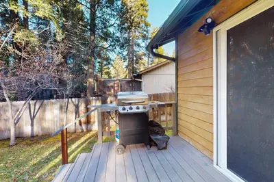 a grill on a deck next to a house at Whispering Pines Retreat in South Lake Tahoe