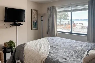 a bedroom with a bed and a tv and a window at Lakeview Gem in South Lake Tahoe