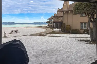 a view of a beach with a bench and a house at Lakeview Gem in South Lake Tahoe