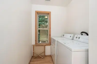 a white laundry room with a washer and a window at Mountain Paradise- Family Cabin w Pool Table in Shaver Lake