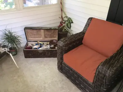 a wicker chair sitting in a room with a box at Beautiful house by the river and the villager in Fair Oaks