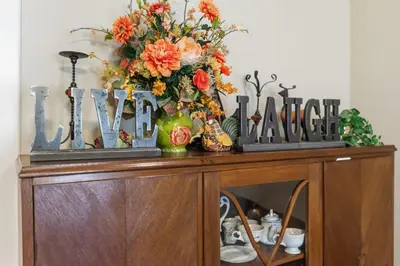 a wooden table with flowers on top of it at Beautiful house by the river and the villager in Fair Oaks