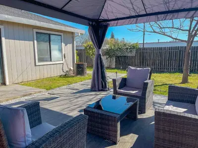 a patio with two chairs and a table and an umbrella at Beautiful 2 bedroom 2 bathroom house in North Highlands