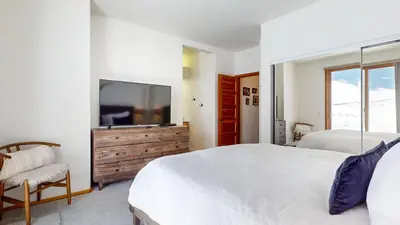 a bedroom with two beds and a flat screen tv at Snowcreek V #777 condo in Mammoth Lakes