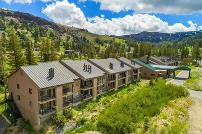 an aerial view of a building with mountains in the background at The Meadows-Cozy Family Condo in Kirkwood Deck in Kirkwood