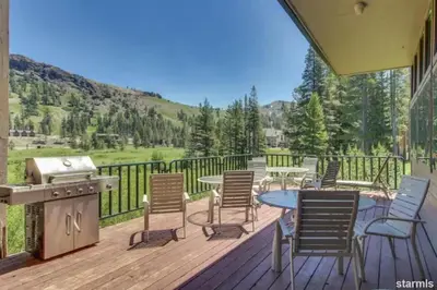 a deck with chairs and a table and a grill at The Meadows-Cozy Family Condo in Kirkwood Deck in Kirkwood