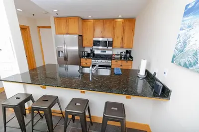 a kitchen with a counter with stools around it at The Meadows - 2 Bdrm Family Condo in Kirkwood in Kirkwood