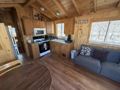 a kitchen and living room in a wooden cabin at Boulder Creek RV Resort in Lone Pine