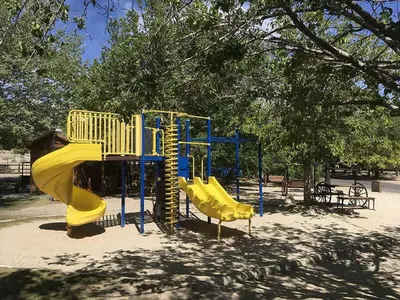 a playground with a slide in a park at Boulder Creek RV Resort in Lone Pine