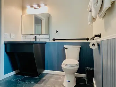 a bathroom with a toilet and a sink and a mirror at Boulder Creek RV Resort in Lone Pine