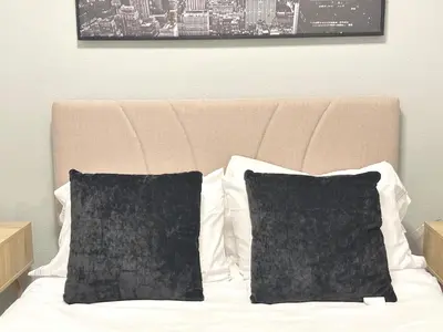 a bed with black and white pillows on it at Cozy 3 Bedroom Walk to UC Davis Medical Near Midtown in Sacramento