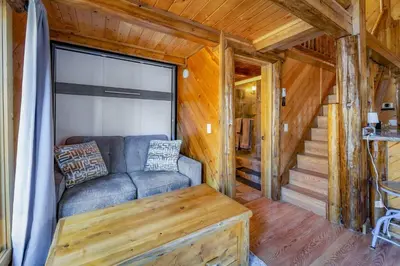 a living room with a couch and stairs in a cabin at Tramway Loft Cozy Stay for 4 in Stateline