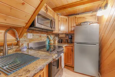 a kitchen with a stainless steel refrigerator and wooden cabinets at Tramway Loft Cozy Stay for 4 in Stateline