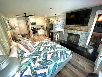 a living room with a couch and a tv and a fireplace at Ski in or Walk to lifts hot tub covered parking in Kirkwood