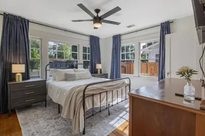 a bedroom with a bed and a desk and windows at 2 bed, 2 bath, historic beauty, walk downtown in Visalia