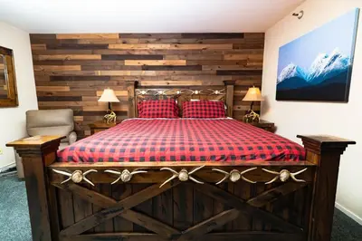a bedroom with a large wooden bed with red pillows at Ski in out King bed Suite Mountain View in Kirkwood