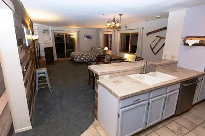 a kitchen with a sink and a living room with a couch at Ski in Ski out Dream Studio Village Mtn Views in Kirkwood