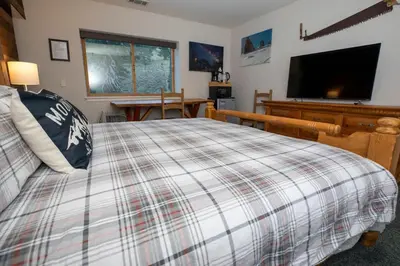 a bedroom with a bed and a flat screen tv at True Ski in out Large 2 bdrm Mtn Views 4 beds in Kirkwood