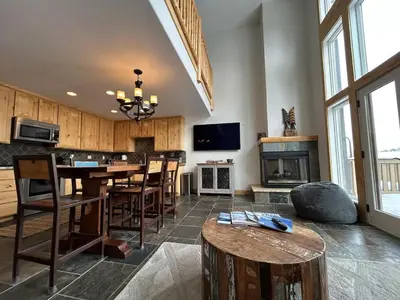 a large living room with a table and a fireplace at Kirkwood Resort between Village & Timber Creek in Markleeville