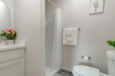 a white bathroom with a toilet and a sink at Great for Digital Nomads! Convenient Manteca Apt in Manteca