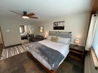 a bedroom with a large bed with a ceiling fan at The Meadows- Modern 1BedroomDeck and Fireplace in Kirkwood