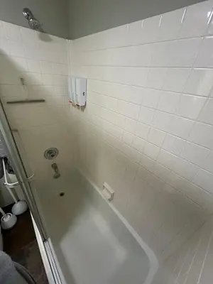 a bathroom with a tub and white tiles at The Meadows- Modern 1BedroomDeck and Fireplace in Kirkwood