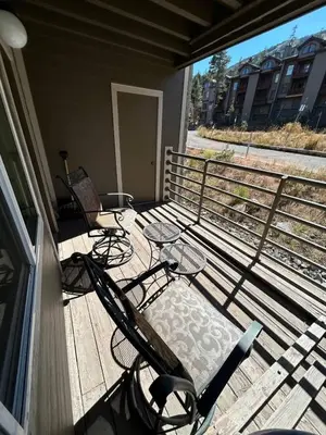a deck with chairs and tables on a balcony at The Meadows Modern Suite Deck & Garage Parking in Kirkwood