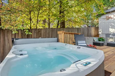 a large hot tub in a backyard with a chair at Luxury Cabin in Budget-Hot Tub -Apple Hills-Tahoe in Pollock Pines