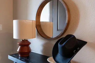 a hat and a lamp on a table with a mirror at Dusty Sage Hollow in Fernley