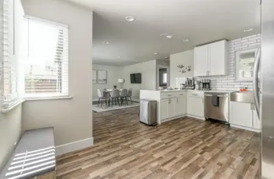 a kitchen with white cabinets and a hard wood floor at Pet-Friendly Home - Big Yard for Family Stays in Sacramento