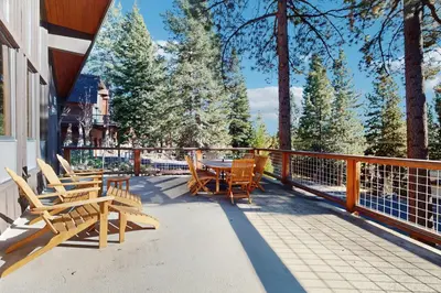 a deck with wooden chairs and tables and trees at Alpenglow at Dollar Point in Dollar Point