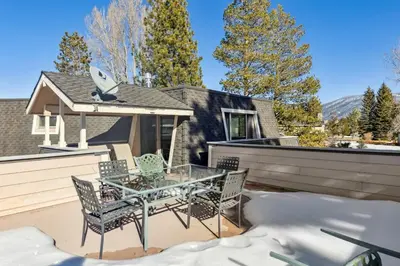 a patio with a glass table and chairs in front of a house at 2253 Catalina Drive home in South Lake Tahoe