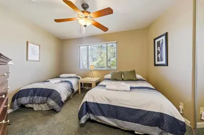 two beds in a room with a ceiling fan at 2253 Catalina Drive home in South Lake Tahoe