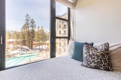 a bed with pillows in a room with a large window at Mammoth Monache Resort in Mammoth Lakes