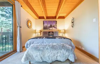 a bedroom with a bed in a room with a window at Family cabin on resort at Northstar in Truckee