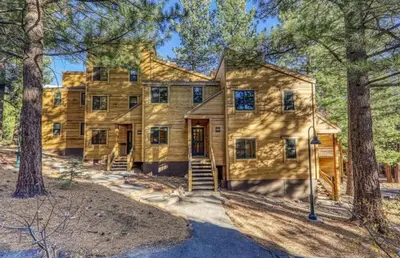 a large wooden house in the middle of trees at Family cabin on resort at Northstar in Truckee