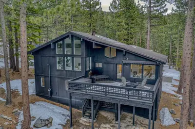 a black house in the middle of a forest at Tahoe Retreat - Private Hot Tub & Scenic Views in Incline Village