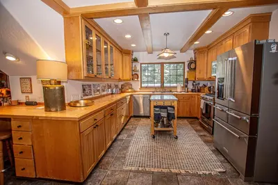 a kitchen with wooden cabinets and a stainless steel refrigerator at Nightingale's Nest in Carnelian Bay