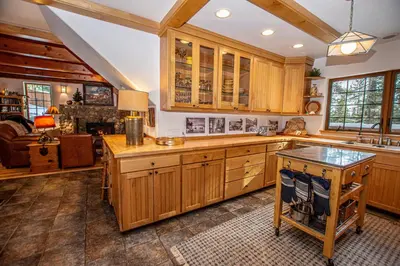 a large kitchen with wooden cabinets and a table at Nightingale's Nest in Carnelian Bay