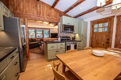 a kitchen and dining room with a wooden table at Cedar Cottage in Homewood