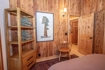 a room with a wooden wall with a book shelf at Cedar Cottage in Homewood